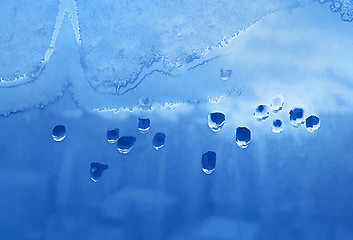 Image showing Water drops, ice pattern and sunlight on window glass