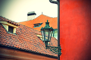 Image showing Traditional street lamp and the tiled roofs of Prague