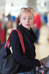 Image showing Female traveler using cell phone while waiting on airport.