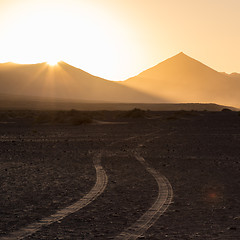 Image showing Wheel tracks in sand in dramatic landscape.