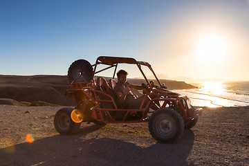 Image showing Man driving quadbike in sunset.