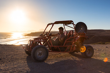 Image showing Man driving quadbike in sunset.