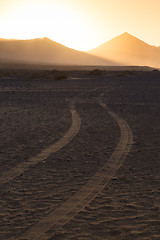 Image showing Wheel tracks in sand in dramatic landscape.