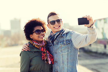 Image showing happy teenage friends in shades taking selfie