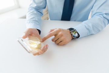 Image showing close up of hands with smart phone and watch