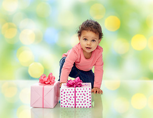 Image showing baby girl with birthday presents and confetti