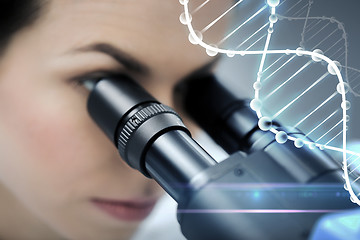 Image showing close up of scientist looking to microscope in lab