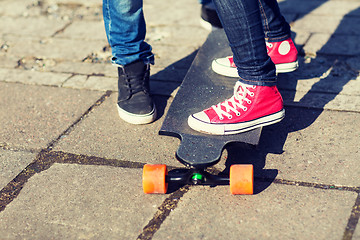 Image showing close up of couple with longboard on street