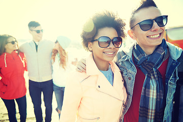 Image showing happy teenage friends in shades hugging on street