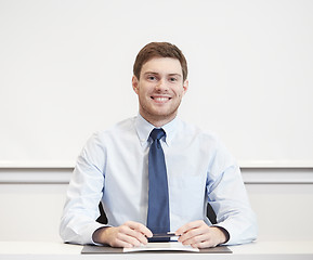 Image showing smiling businessman sitting in office