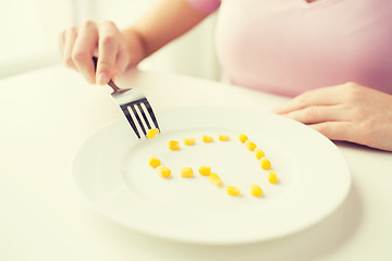 Image showing close up of woman with fork eating corn