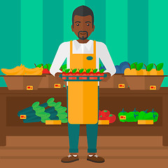 Image showing Supermarket worker with box full of apples.