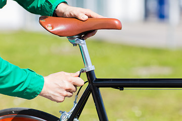 Image showing close up of man adjusting fixed gear bike saddle