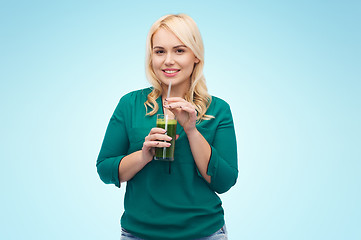 Image showing smiling woman drinking vegetable juice or smoothie