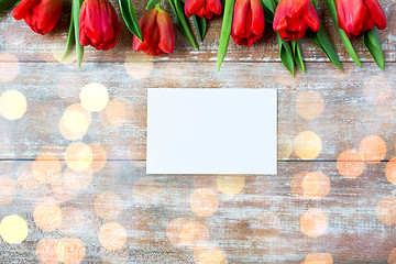 Image showing close up of red tulips and blank paper or letter