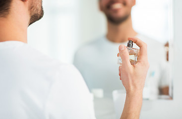 Image showing close up of man perfuming with perfume at bathroom