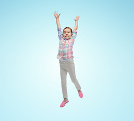 Image showing happy little girl jumping in air over blue