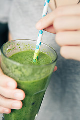 Image showing woman holding a glass of green smoothie