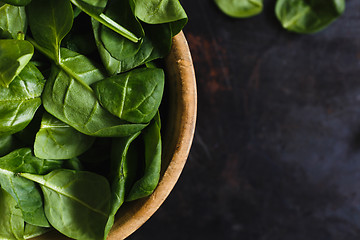 Image showing Fresh spinach leaves in a wooden bowl