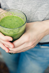 Image showing woman holding a glass of green smoothie