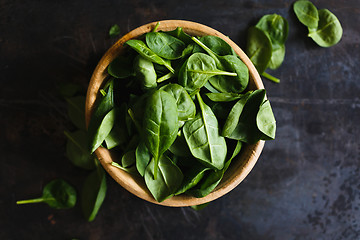 Image showing Fresh spinach leaves in a wooden bowl