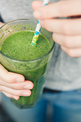 Image showing woman holding a glass of green smoothie