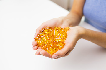 Image showing close up of woman hands holding pills or capsules