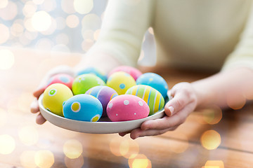 Image showing close up of woman hands with colored easter eggs