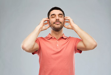 Image showing happy man listening to music over gray background