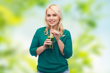 Image showing smiling woman drinking vegetable juice or smoothie