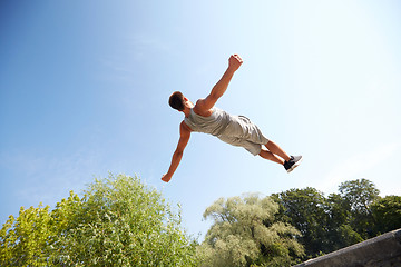 Image showing sporty young man jumping in summer park