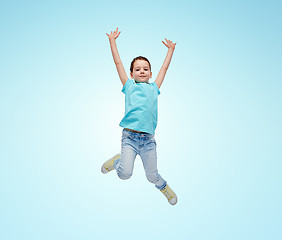 Image showing happy little girl jumping in air over blue