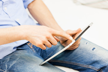 Image showing close up of man working with tablet pc at home