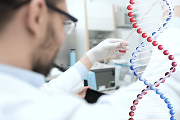 Image showing close up of scientist with tube and pipette in lab