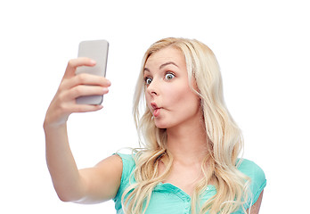 Image showing funny young woman taking selfie with smartphone