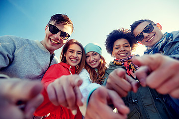 Image showing happy teenage friends pointing fingers on street