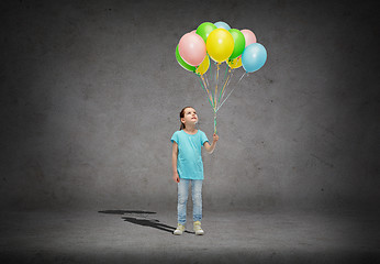 Image showing girl looking up with bunch of helium balloons