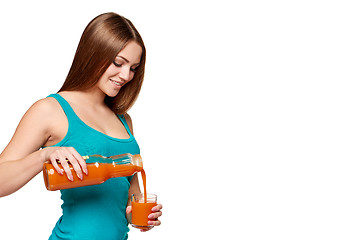 Image showing Woman pouring carrot juice in a glass