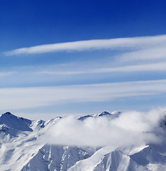 Image showing Snow mountains in clouds at sun day