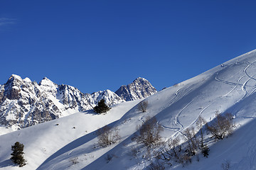 Image showing Off-piste slope with track from ski and snowboard on sunny morni