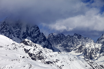 Image showing Snowy rocks in clouds at sunny day