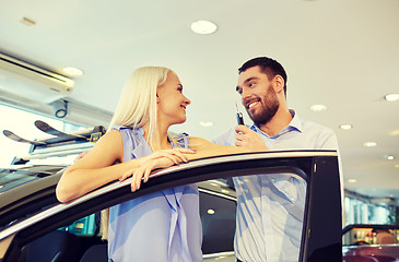 Image showing happy couple buying car in auto show or salon