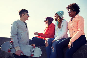 Image showing happy teenage friends with longboard on street