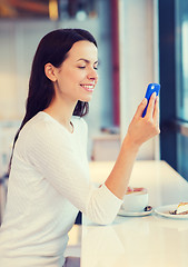 Image showing smiling woman with smartphone and coffee at cafe