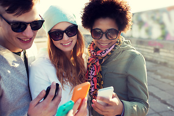Image showing smiling friends with smartphones