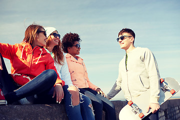 Image showing happy teenage friends with longboard on street