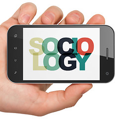 Image showing Studying concept: Hand Holding Smartphone with Sociology on  display