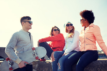 Image showing happy teenage friends with longboard on street