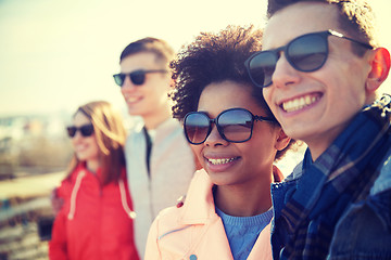 Image showing happy teenage friends in shades hugging on street