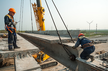 Image showing Two workers mouning bridge span